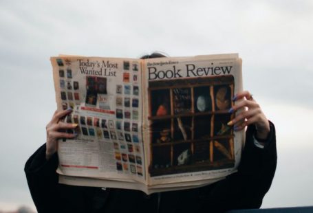 Reviews - Person Holding White and Brown Newspaper