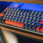 Ergonomic Solutions - From above contemporary mechanical keyboard of black and red colors with lightning placed on wooden computer desk