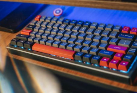 Ergonomic Solutions - From above contemporary mechanical keyboard of black and red colors with lightning placed on wooden computer desk