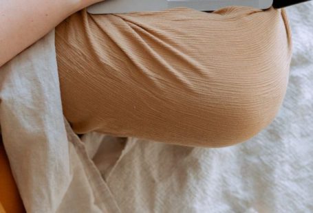 Home Wi-Fi - Anonymous woman in casual clothes sitting on sofa and browsing laptop with blank screen while working on project on bed