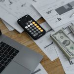 Budget Smartphones - Banknotes and Calculator on Table