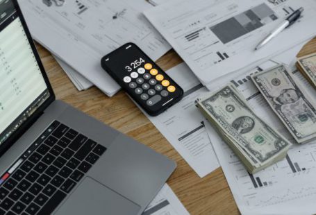 Budget Smartphones - Banknotes and Calculator on Table