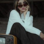 4K TV - A Woman Sitting beside a Vintage Television