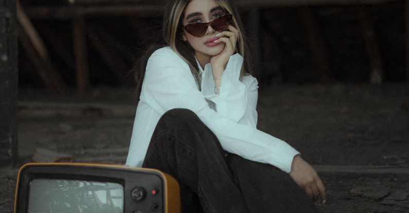 4K TV - A Woman Sitting beside a Vintage Television