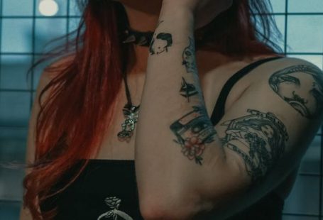 Alternatives - Woman in Black Tank Top With Tattoo on Her Left Hand