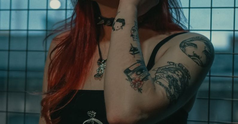 Alternatives - Woman in Black Tank Top With Tattoo on Her Left Hand
