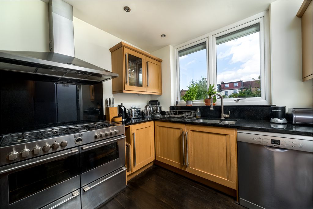 A stylish modern kitchen featuring wooden cabinets and stainless steel appliances.