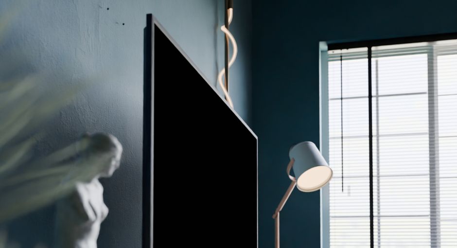 A stylish modern room featuring a statue, flat screen TV, and window light.