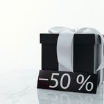 Elegant black gift box tied with a white ribbon, featuring a 50% discount tag.