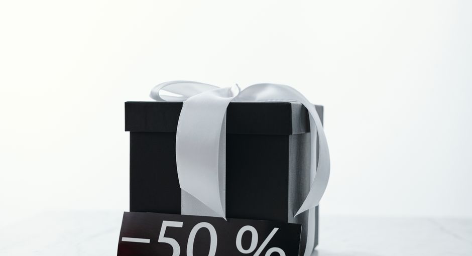 Elegant black gift box tied with a white ribbon, featuring a 50% discount tag.