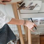 High angle of crop anonymous female photographer using printer for making images while working in flat