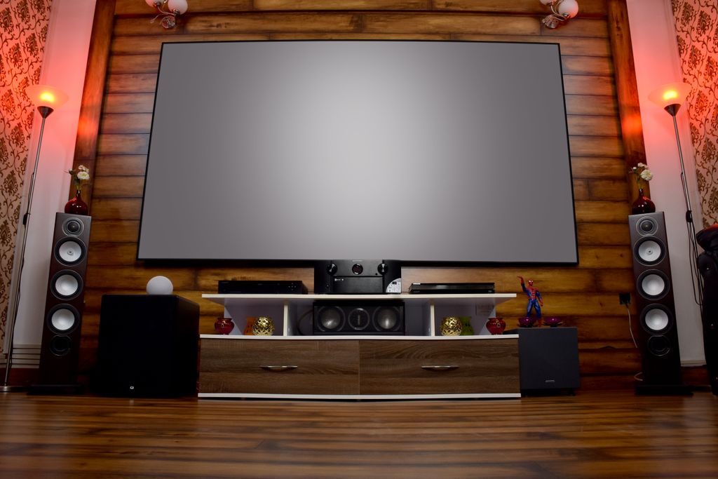 Stylish home theater featuring large screen, audio system, and decor, perfect for entertainment.